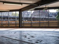 a empty parking space next to some windows in a building with a balcony area overlooking the train tracks