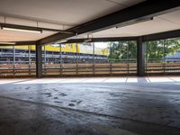a empty parking space next to some windows in a building with a balcony area overlooking the train tracks
