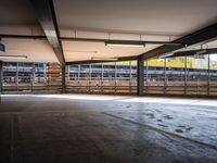 a empty parking space next to some windows in a building with a balcony area overlooking the train tracks