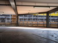 a empty parking space next to some windows in a building with a balcony area overlooking the train tracks