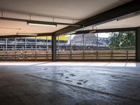 a empty parking space next to some windows in a building with a balcony area overlooking the train tracks