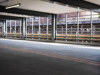 a empty parking space next to some windows in a building with a balcony area overlooking the train tracks