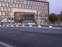 empty parking spaces along the road in front of buildings of many sizes and shapes with railings on either side