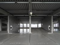 two empty parking spaces on concrete floors and ceilings with metal mesh dividers across them