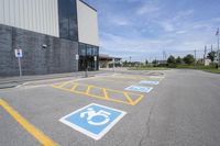 an empty parking lot with yellow and blue handicapped lanes on the road near the building