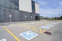 an empty parking lot with yellow and blue handicapped lanes on the road near the building