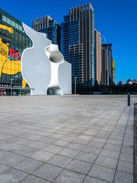 the apple logo is seen on the side of an empty plaza in a large city