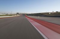 the race track is empty and red as the car drives past it on its way to a win