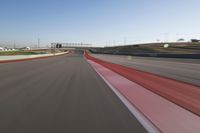 the race track is empty and red as the car drives past it on its way to a win