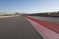 the race track is empty and red as the car drives past it on its way to a win