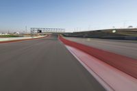 the race track is empty and red as the car drives past it on its way to a win