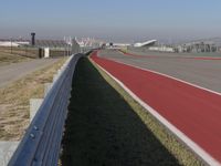 an empty track at a motorsports club with some red and white stripeing on it