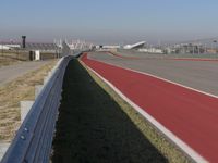 an empty track at a motorsports club with some red and white stripeing on it