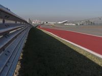 an empty track at a motorsports club with some red and white stripeing on it