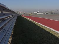 an empty track at a motorsports club with some red and white stripeing on it