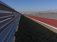 an empty track at a motorsports club with some red and white stripeing on it