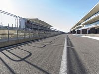 an empty race track with only a few people standing and waiting for the start to begin