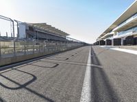 an empty race track with only a few people standing and waiting for the start to begin