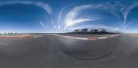 an empty race track is shown from a fish eye lens and a car on the side of the road