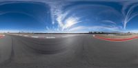 the view from a 360 - view camera looking at an empty track with swirly clouds in the background