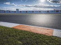 the green road and orange and white stripe line at an event near the racetrack and stadium