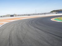 the green road and orange and white stripe line at an event near the racetrack and stadium