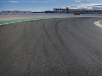 the green road and orange and white stripe line at an event near the racetrack and stadium