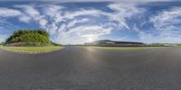 a view of an empty racing track from below and behind the camera lens, with a lot of grass