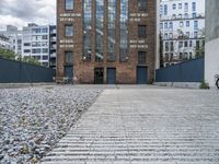 the entrance to an old red brick building is empty and covered with rock stones on a city street