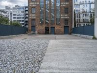 the entrance to an old red brick building is empty and covered with rock stones on a city street