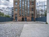 the entrance to an old red brick building is empty and covered with rock stones on a city street