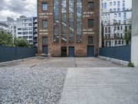 the entrance to an old red brick building is empty and covered with rock stones on a city street