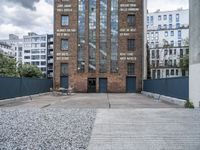 the entrance to an old red brick building is empty and covered with rock stones on a city street