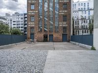 the entrance to an old red brick building is empty and covered with rock stones on a city street
