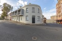 an empty residential property is situated in the city street corner, with two buildings and no one is standing in front