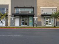 an empty retail center with shops lining the street from it to the sidewalk, a curb or street