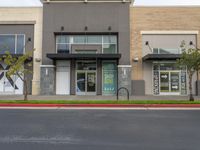 an empty retail center with shops lining the street from it to the sidewalk, a curb or street