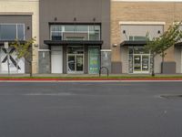 an empty retail center with shops lining the street from it to the sidewalk, a curb or street