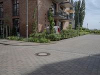 an empty road is lined with apartment buildings in the background and on either side there is a street sign with trees