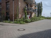 an empty road is lined with apartment buildings in the background and on either side there is a street sign with trees