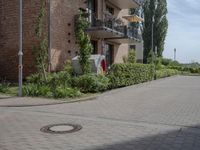 an empty road is lined with apartment buildings in the background and on either side there is a street sign with trees