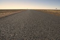 the empty open road is empty at night time near the horizon, and a single lone object is visible in the distance