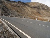 an empty highway with mountains in the background at the bottom of it and a street light