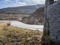 a person is going down an empty highway with mountains in the background during the day