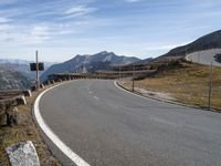 an empty road with the mountains in the back ground and rocks on the sides of the road