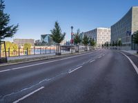 the empty road near some tall buildings in a city neighborhood near the water with an arrow pointing to the building