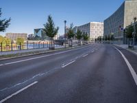 the empty road near some tall buildings in a city neighborhood near the water with an arrow pointing to the building