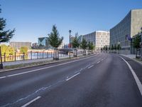 the empty road near some tall buildings in a city neighborhood near the water with an arrow pointing to the building