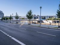 a empty road with several trees and buildings on either side of it near an intersection