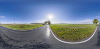 the panoramic view is of an empty road in the daytime time of day